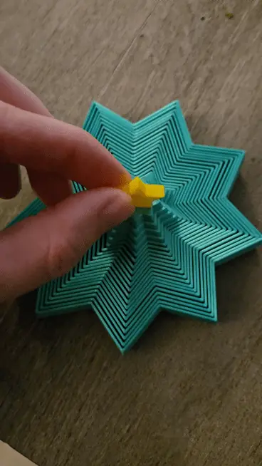 Animation of a teal fidget being pulled up into a tree and pushed back down flat