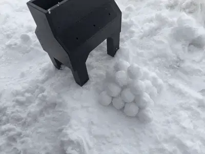 Looking down into the snowball machine's hopper at the two rollers that shape the snowballs